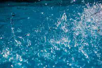 Closeup of a splash taking place over the surface of a crystal clear water