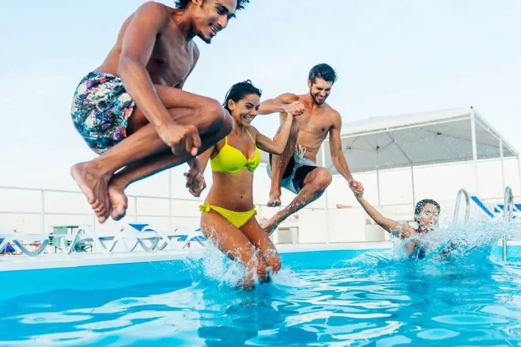 Group of friends having fun in swimming pool on a sunny day