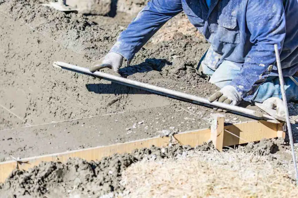 Pool Construction Worker Working With A Smoother Rod On Wet Concrete