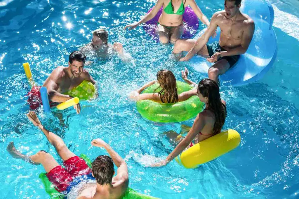 Group of friends having fun in swimming pool on a sunny day