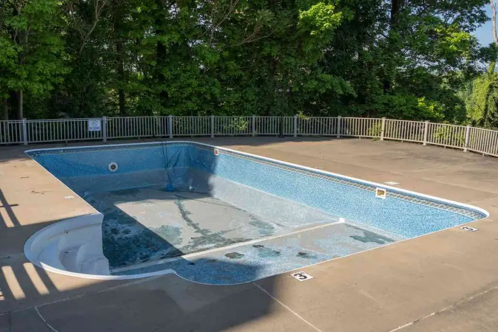 Empty in ground swimming pool ready for replacement of old vinyl lining or liner